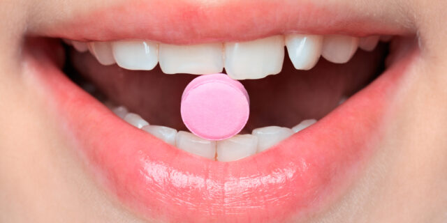 Close-up,Of,Pink,Pill,In,Woman's,Mouth